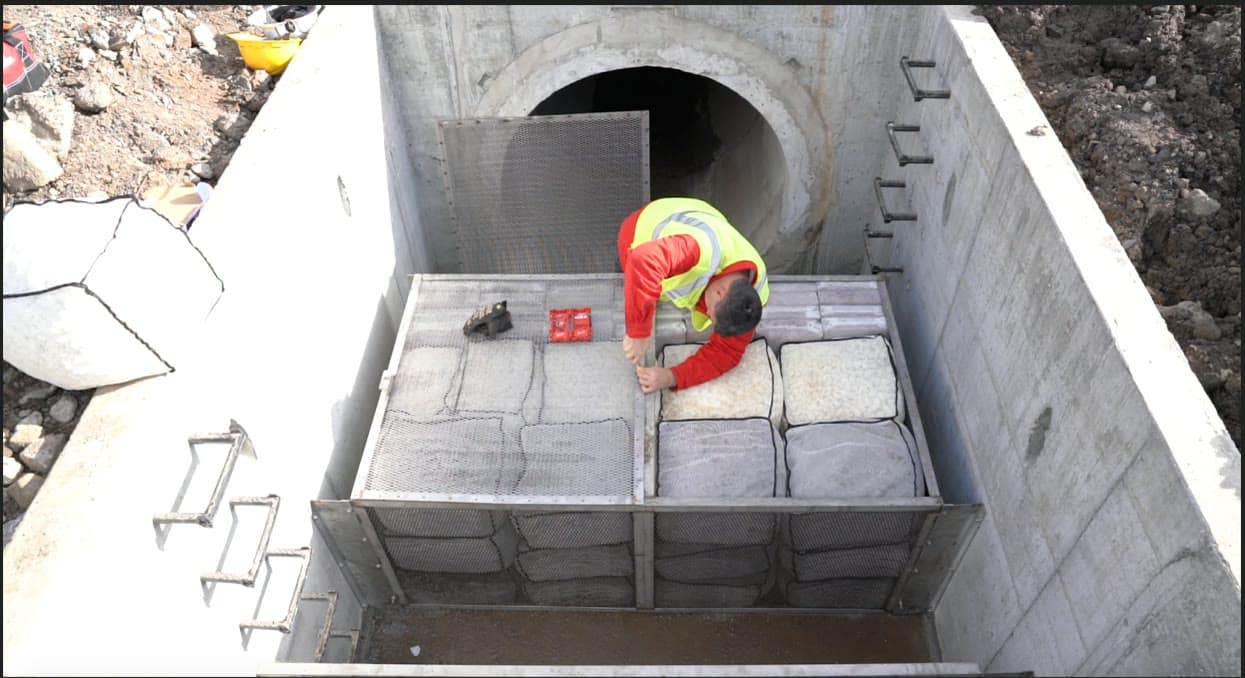 A worker installs Smart Sponge filtration media inside a concrete stormwater treatment vault.